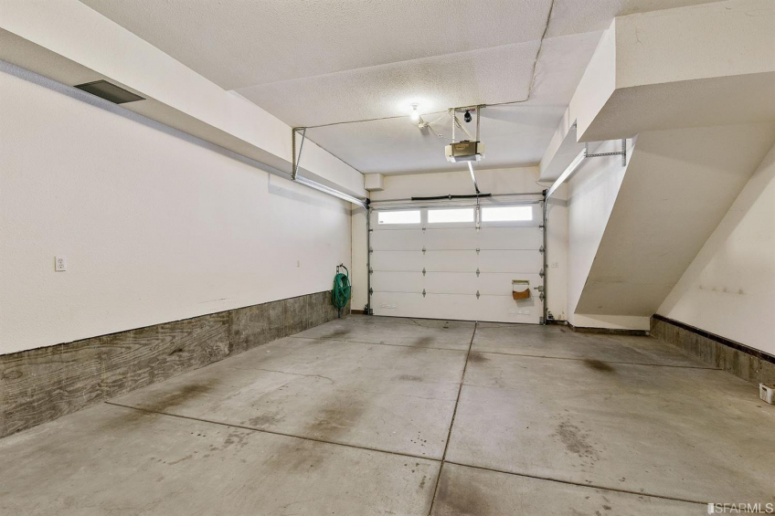 A large 2 car garage with side by side parking, a laundry area, and room for storage. Resource #323377: image #44